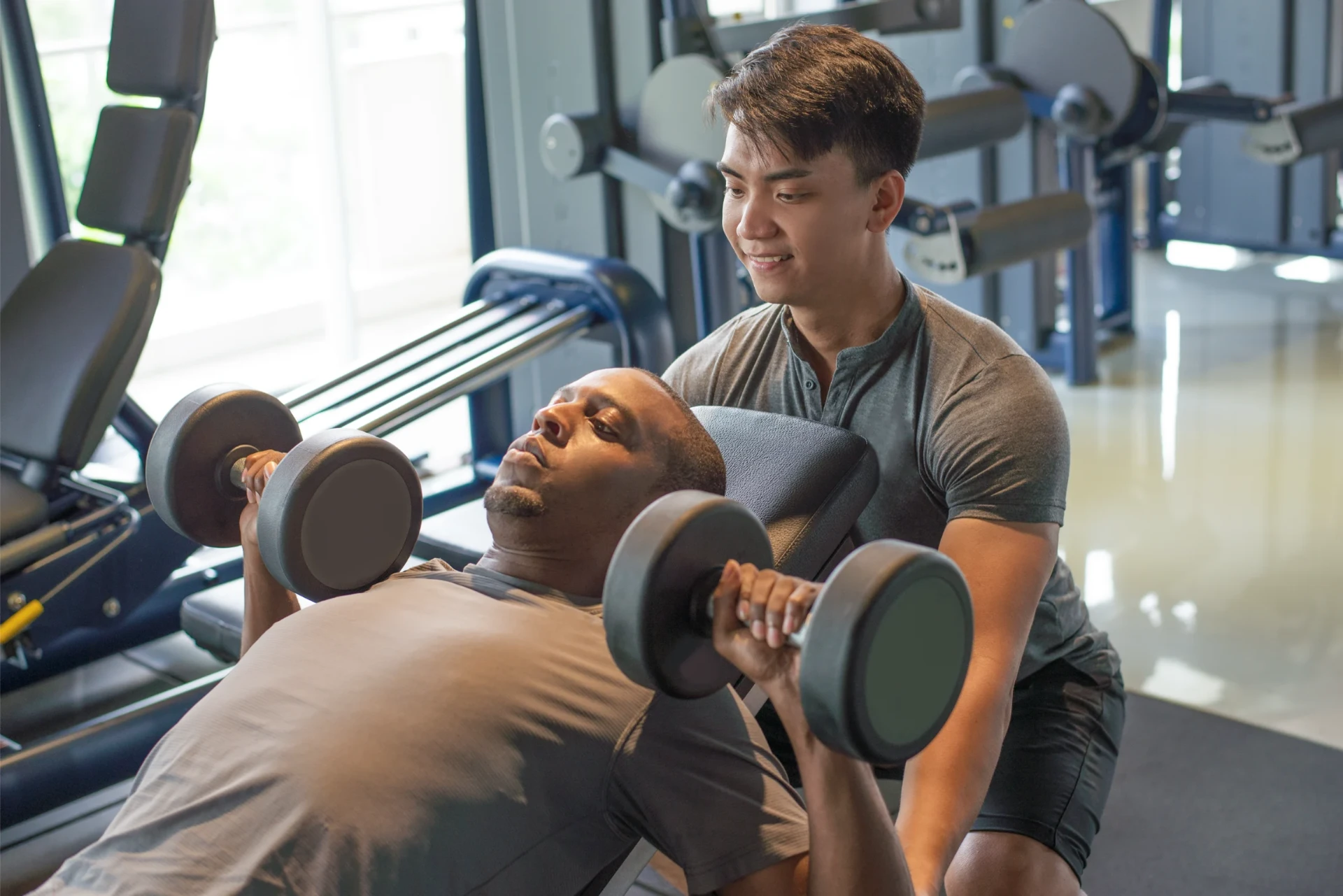 Coach training a client at the gym